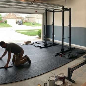 Man installing his own home gym in a garage