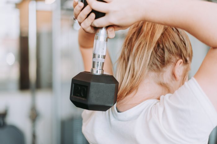 A woman working out with a dumbbell weight