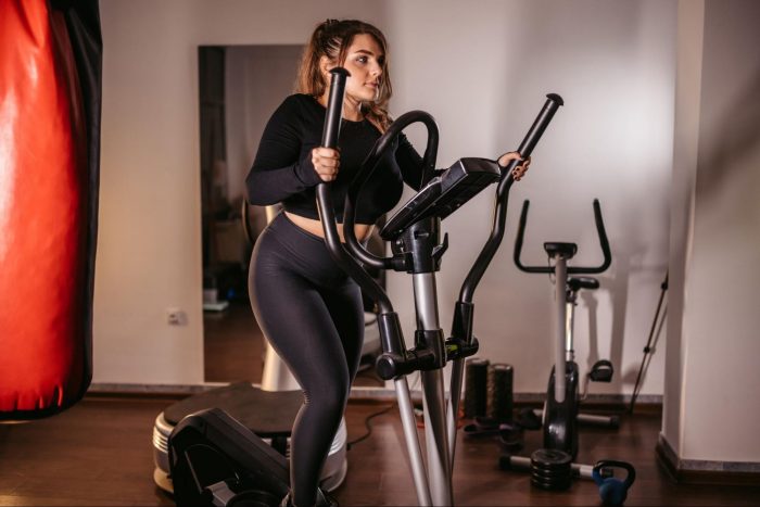Woman wearing black on a cross trainer
