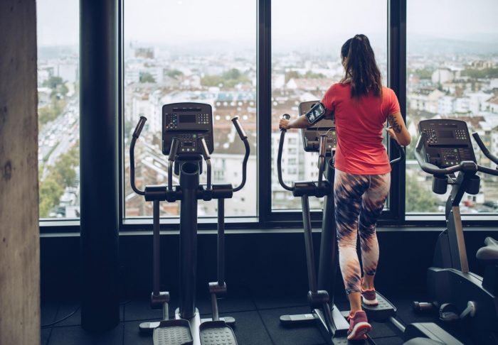 Woman in gym working out on cross trainer
