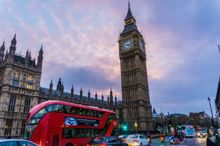Big Ben in London with a red bus outside in traffic