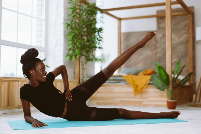 Woman completing a side leg raise on a mat