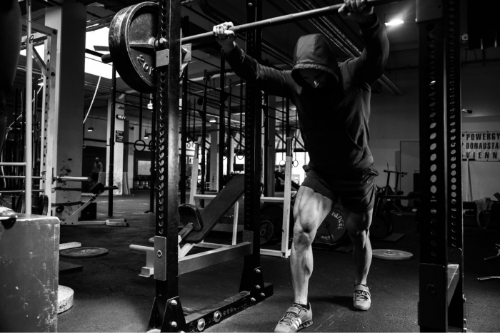Men about to perform a squat in a gym