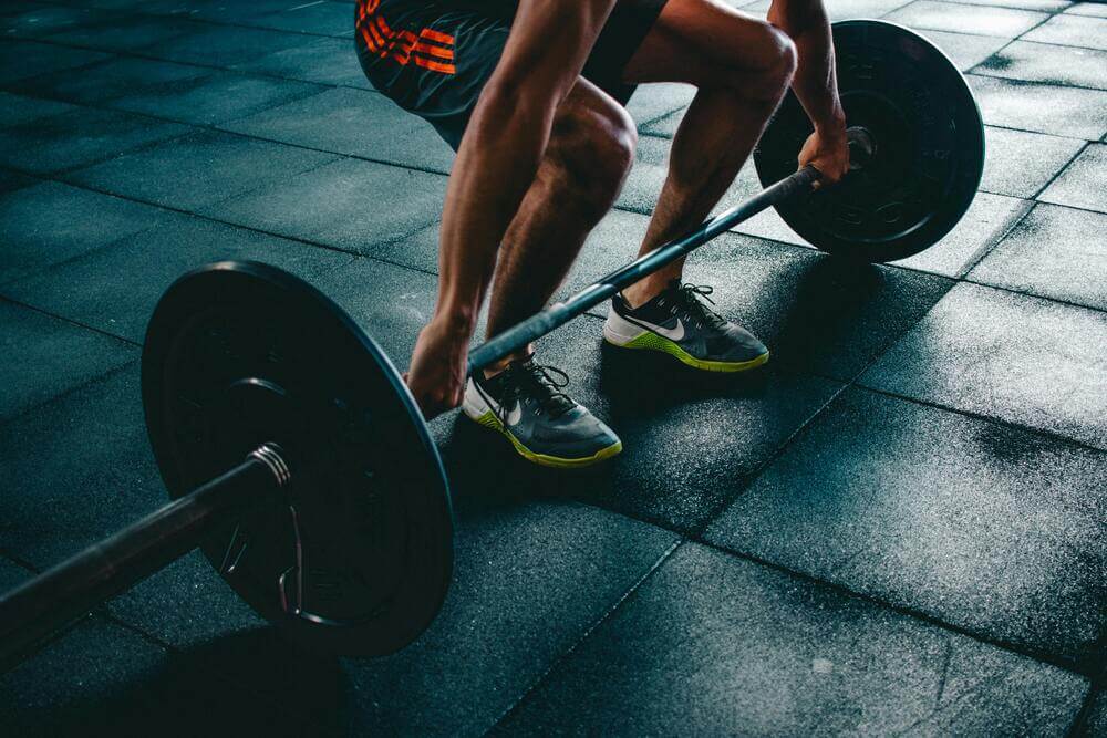 Man picking up a barbell weight for strength training