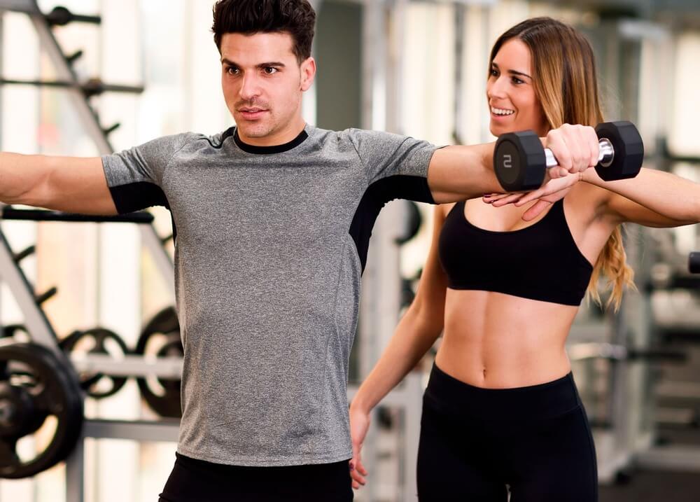 A man having a PT session with a female personal trainer