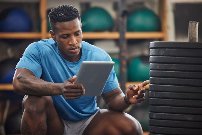 Gym owner with an iPad counting the number of weights in a gym