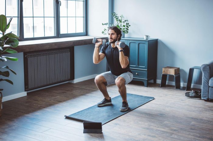 Man in shorts completing a workout in his home gym