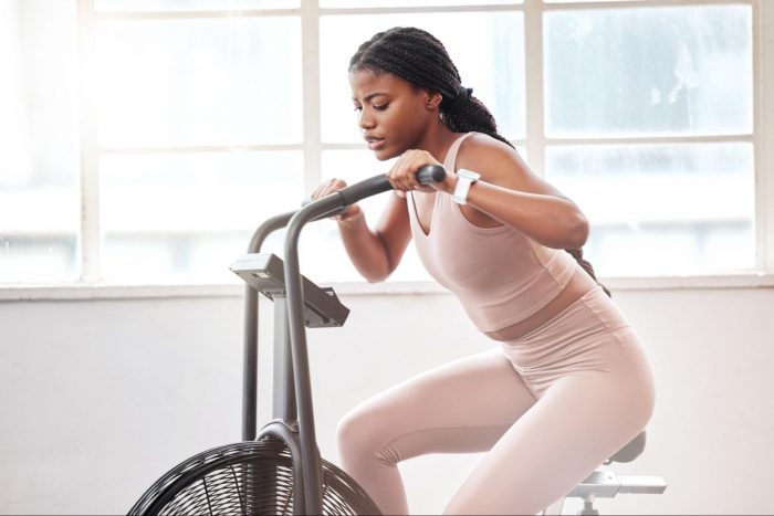 Woman in a pink gym set on an air bike