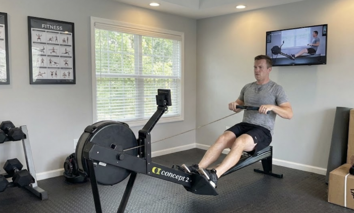 Man on a rowing machine in his garage
