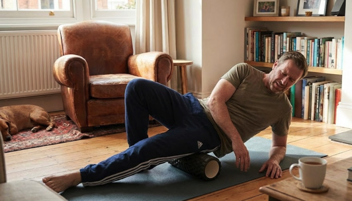 Man foam rolling at home 