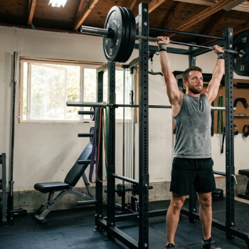 Man lifting barbell in home gym