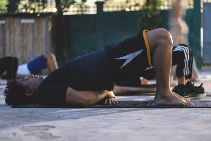 Man doing a glute bridge on a yoga mat